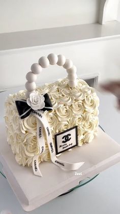 a cake with white frosting and black bows on it's head is sitting on a table