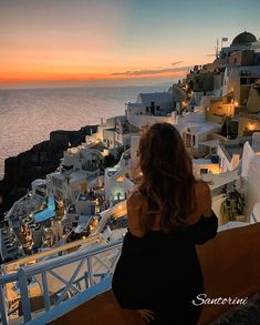 a woman looking out over the ocean at sunset in oiai, paros