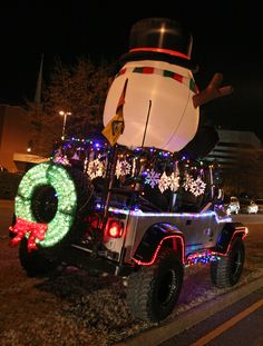 a truck decorated with christmas lights and an inflatable snowman