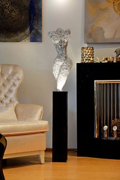 a living room filled with furniture next to a wall mounted art piece on top of a wooden floor