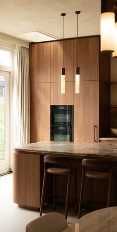 a kitchen with wooden cabinets and stools next to an oven in the middle of it