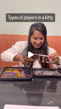 a woman sitting at a table with two trays filled with different types of items