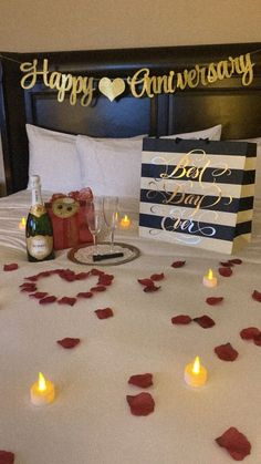 a bed with rose petals and candles on it