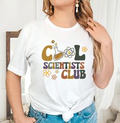 Cool Scientists Club Shirt, Science Teacher Shirt, Back to School Teacher Shirt, Science Lover Shirts, Stem Student Shirt, Scientist Shirt HOW TO PLACE YOUR ORDER * Choose your t-shirt color * Choose your size * Choose your design&text color * PLEASE make sure all your order's steps PRODUCT DESCRIPTION T-shirt feels soft and light, with just the right amount of stretch. It's comfortable and the unisex cut is flattering for both men and women. * Solid colors are 100% combed and ring-spun cotton * Ash color is 99% combed and ring-spun cotton, 1% polyester * Heather colors are 52% combed and ring-spun cotton, 48% polyester * Athletic and Black Heather are 90% combed and ring-spun cotton, 10% polyester * Heather Prism colors are 99% combed and ring-spun cotton, 1% polyester * Fabric weight: 4. Relaxed Fit School Top With Funny Print, Retro Cotton Slogan Shirt, Retro White Shirt With Funny Print, Retro Relaxed Fit Tops For School, Retro Graphic Print Tops For School, Casual School Tops With Funny Print, Casual Tops With Funny Print For School, Retro Slogan Tops For School, Retro School Tops With Slogan