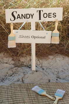 two toothbrushes sitting on top of a sign that says sandy toes shoes optimal