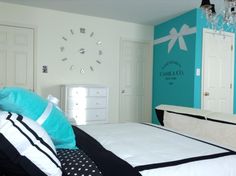 a bedroom with blue and white walls, black and white bedding, and a chandelier hanging from the ceiling