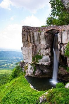 a waterfall is coming out of the side of a cliff