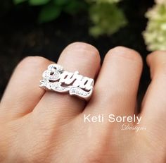 "Personalized name in pretty script font miraculously detailed by our talented jewelers. Amazing custom made jewelry for birthdays, mother's day, Christmas, graduation and etc. Ring will be featured with sparkling Cubic Zirconia stones in first letter and under design. Metal: * Sterling Silver * Sterling Silver with yellow gold overlay * Sterling Silver with rose gold overlay * 10K solid gold (yellow, rose or white gold) * 14K solid gold (yellow, rose or white gold) Sizes - 6 to 10 For larger si Personalized Silver Engraved Ring With Cubic Zirconia, Personalized Cubic Zirconia Engraved Wedding Ring, Personalized White Gold Cubic Zirconia Rings, Personalized White Gold Rings With Cubic Zirconia, Silver Nameplate Rings For Anniversary, Personalized Cubic Zirconia Ring Jewelry, Silver Jewelry With Diamond Accents For Birthday, Custom Silver Jewelry With Name, Personalized Silver Engraved Ring For Mother's Day