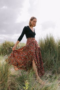 Hand block printed, creating sustainable livelihoods for female artisans. The Maxi Wrap Skirt in Paisley Maroon is seasonless by design. Made from soft, light cotton the wrap skirt is incredibly comfortable, offering style with flattering movement from the waist. Gathers and ties at the side or back of the waist. Crafted with three waist loopholes for an adjustable, flexible fit. Upper ankle Length. Model is 5'8 tall, size UK 10, US 6 and is wearing the S/M. Printed onto 100% cotton. Plant-based Paisley Skirt Outfit, Wrap Skirt Outfit, Maxi Wrap Skirt, Wishlist 2024, Midi Wrap Skirt, Ethical Fashion Brands, Wrap Maxi Skirt, Versatile Outfits, Soft Light