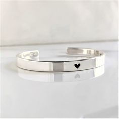 "* DETAILS:  - one .925 Solid Sterling 1/4\" x 6\", 6.5\", 7\", 7.5\" or 8\" cuff bracelet with a small heart engraved on the center - inside text, 50 characters or less - all cuffs can be adjusted with slight pressure to be made tighter or looser » DON'T FORGET TO GRAB A SUNSHINE POLISHING CLOTH: https://www.etsy.com/listing/469627127/sunshine-cleaning-cloth-for-jewelry?ref=shop_home_active_1 » CHECK OUT MY ENTIRE SHOP https://www.etsy.com/shop/TatumBradleyCo?ref=si_shop » My Shop Feedback: https://www.etsy.com/your/shops/TatumBradleyCo/reviews?ref=shop_info" Silver Sterling Silver Name Bracelet For Promise, Classic Bracelets For Anniversary On Valentine's Day, Classic Adjustable Heart Bracelet For Valentine's Day, Adjustable Classic Heart Bracelet For Valentine's Day, Minimalist Bangle Jewelry For Valentine's Day, Minimalist Heart Bangle Bracelet As Gift, Classic Sterling Silver Bracelet For Valentine's Day Gift, Minimalist Silver Heart Bracelet For Anniversary, Stackable Sterling Silver Bracelet For Anniversary