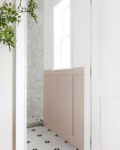 an open door leading to a bathroom with black and white tile