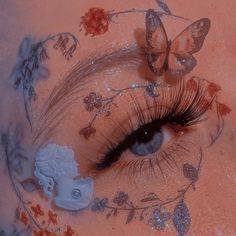 a woman's eye with butterflies and flowers around her, painted on the skin