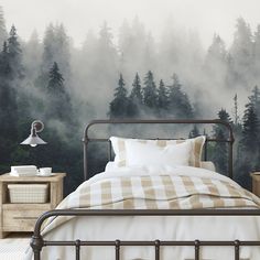 a bedroom scene with focus on the bed and forest wallpapers, along with two nightstands