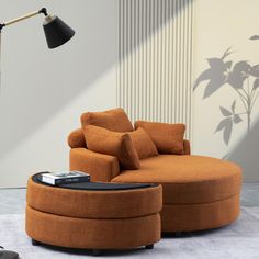 a living room with an orange chair and ottoman next to a black lamp on the floor