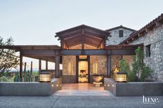 the front entrance to a modern home with cactus and succulents