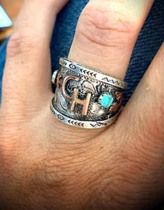 a person wearing a ring with the letter h on it