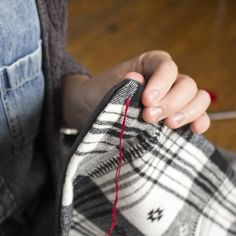 someone is sewing something on the floor with their hands and feet in front of them