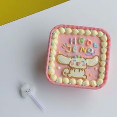 a cake shaped like an elephant on top of a white table next to ear buds