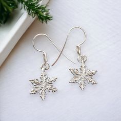 "A Pair of Sterling Silver Snowflake Earrings. Solid .925 Sterling Silver Construction. These Classic Snowflake Charm Earrings are both Cast and Assembled by us here in the USA. You'll receive a Pair. Solid Sterling Silver Construction Charm Size approx : 20mm x 14mm = 3/4+\" tall x 1/2+\" wide Metal : Solid .925 Silver | Solid Sterling Construction Made in the USA  Comes with care-card & Ready to Wear or Gift. Sold by : Pair SOLID STERLING SILVER These Earrings are made from Solid Sterling Silv Sterling Silver Snowflake Jewelry For Winter, Snowflake Shaped Jewelry With Matching Earrings For Gifts, Sterling Silver Dangle Jewelry For Christmas, Handmade Sterling Silver Christmas Earrings, Nickel Free Christmas Drop Earrings, Sterling Silver Jewelry For Winter Gifts, Handmade Silver Jewelry For Christmas, Nickel-free Drop Earrings For Christmas, Silver Handmade Jewelry For Christmas