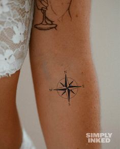 a woman's arm with a compass tattoo on it