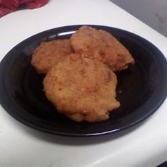 some fried food is on a black plate next to red peppers and a white counter