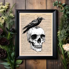 a black bird sitting on top of a skull with flowers in front of the frame