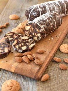 some almonds are on a wooden cutting board and one is filled with nutritious treats