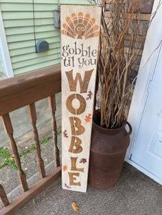 a wooden sign that says gobble it if you wobble next to a potted plant