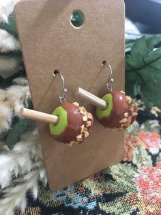 two apples are sitting on top of each other, with a wooden stick sticking out of them