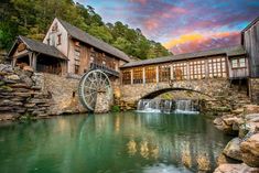 an old mill with a river running under it