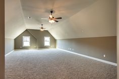 an empty room with carpet and ceiling fan