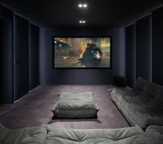 an empty room with two couches and a projector screen on the wall in front of it