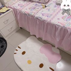 a hello kitty bedroom with pink bedding and white dressers in the corner next to it