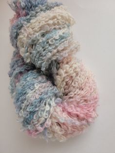 two skeins of multicolored yarn sitting on top of each other in front of a white background