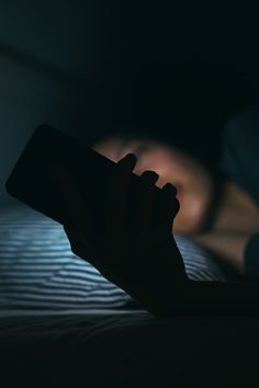 a person is laying in bed with their hand on the remote control, and it appears to be blurry