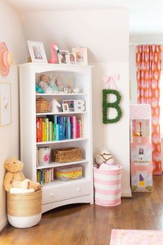 a white book shelf with books and toys on it's shelves in a child's room