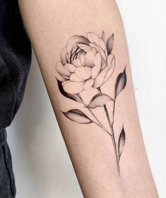 a black and white rose tattoo on the arm