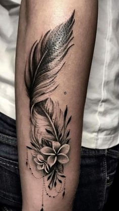 a black and white photo of a feather with flowers on it's side arm