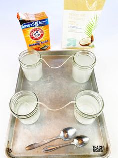 the tray has four cups and spoons on it, along with two packets of coconut milk