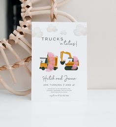 a white card with an image of two construction vehicles on it and the words trucks written in black