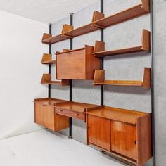 a wall mounted shelf with wooden shelves and drawers