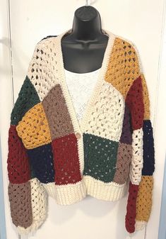 a multicolored sweater hanging on a white door