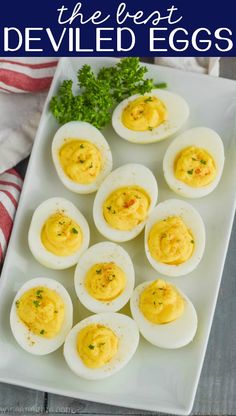 deviled eggs on a white plate with parsley