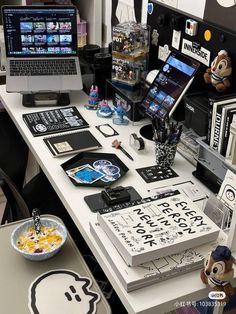 an office desk with various items on it and two laptops sitting next to each other