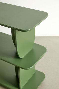 a green table sitting on top of a white floor