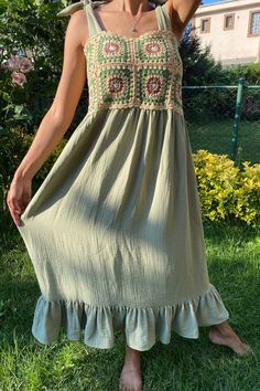 a woman standing in the grass wearing a dress