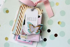 a close up of a tag on a table with polka dot paper and ribbon around it