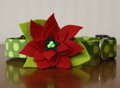 a green and red dog collar with a poinsettia flower on the front