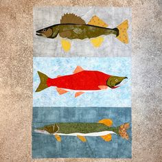 three fish are depicted on the same piece of fabric, each with different colors and sizes