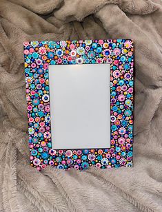 a multicolored photo frame sitting on top of a furnishing covered bed